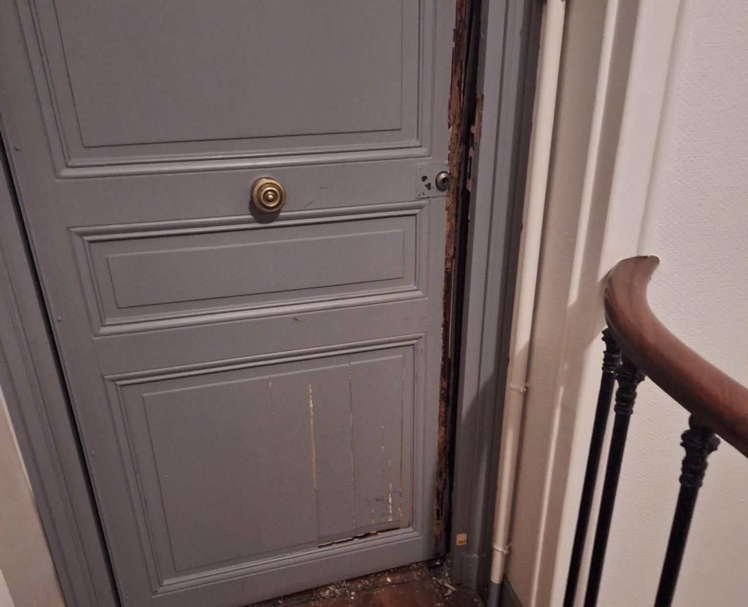 Porte palière d'un immeuble parisien, cage d'escalier à rampe en bois